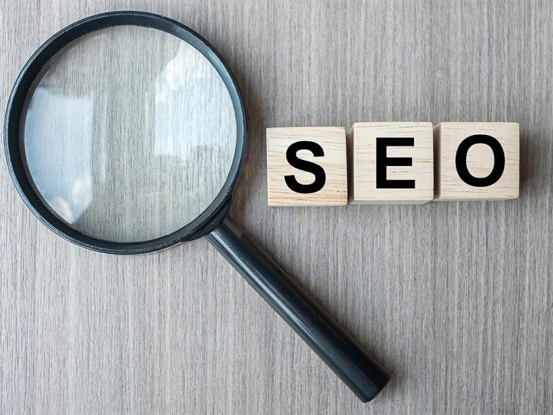 SEO (Search Engine Optimization) text wooden cubes and magnifyin